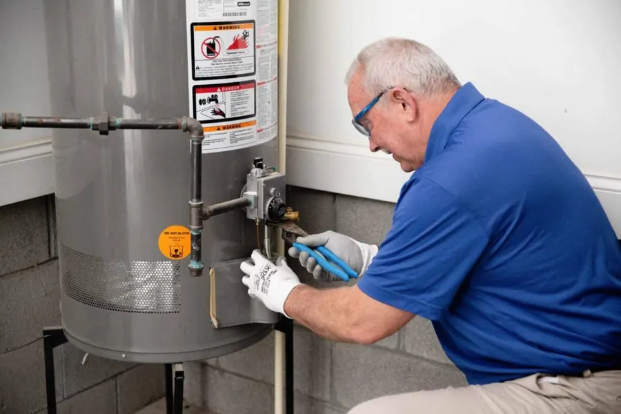 Plumber installing a tankless water heater in a clean utility room